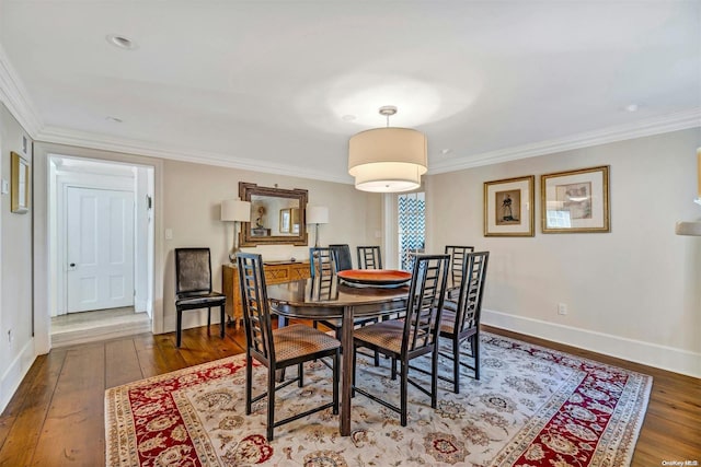 dining space featuring dark hardwood / wood-style flooring and ornamental molding