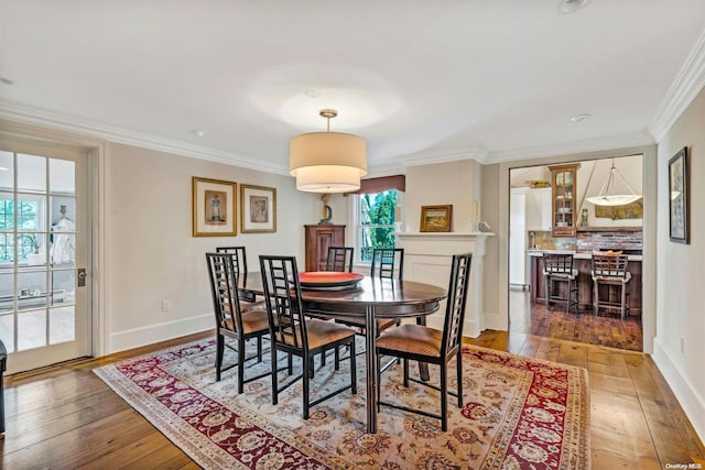 dining room with dark wood-type flooring and ornamental molding