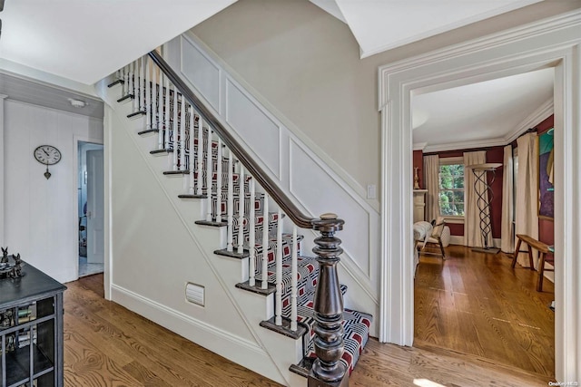 stairway featuring crown molding and wood-type flooring