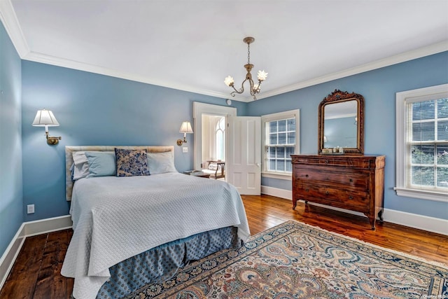 bedroom with dark hardwood / wood-style floors, crown molding, and an inviting chandelier