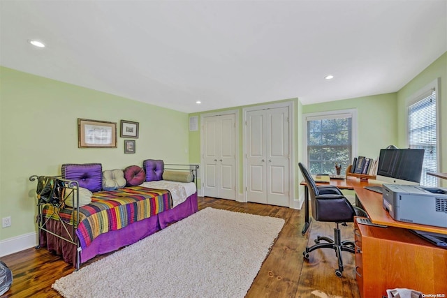 bedroom featuring multiple closets and dark hardwood / wood-style flooring