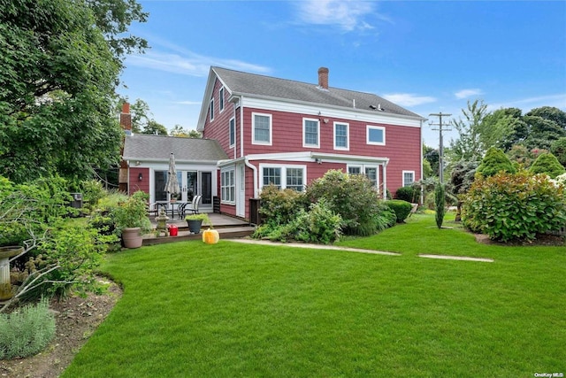 15405 Main Rd, Mattituck, NY 11952 - back of property with a chimney, a yard, a patio, and roof with shingles