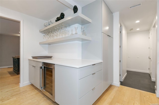 bar featuring light hardwood / wood-style flooring and wine cooler