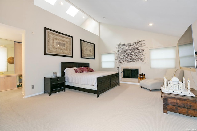 bedroom with high vaulted ceiling, carpet floors, connected bathroom, and a skylight