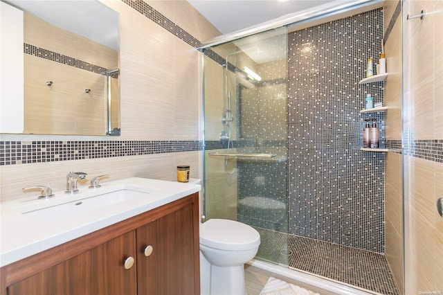 bathroom with vanity, decorative backsplash, toilet, tile walls, and an enclosed shower