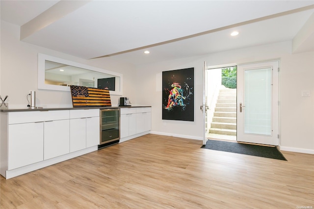 kitchen featuring wine cooler, white cabinetry, and light hardwood / wood-style flooring