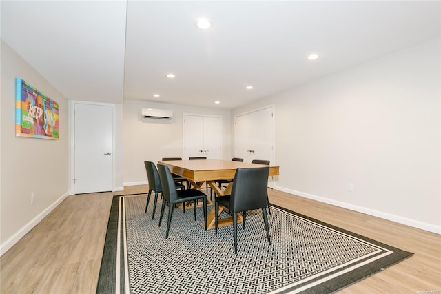 dining room featuring light hardwood / wood-style floors and an AC wall unit