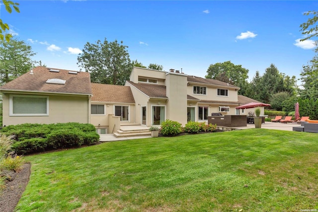 back of property featuring a patio and a lawn