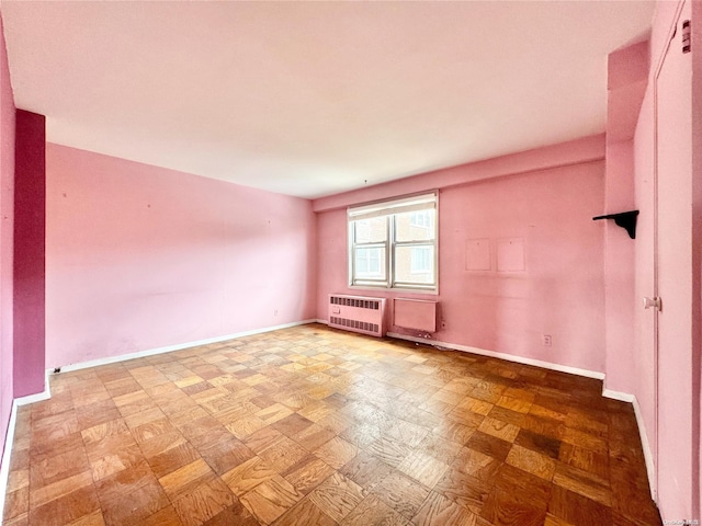 spare room featuring heating unit and light parquet floors