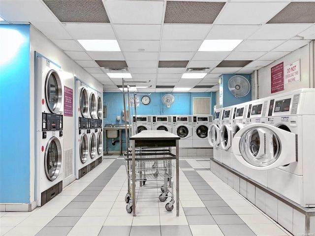 washroom featuring washing machine and dryer, stacked washer and dryer, and light tile patterned floors