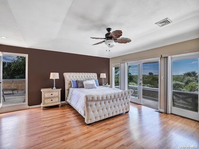 bedroom with ceiling fan, light wood-type flooring, access to outside, and french doors