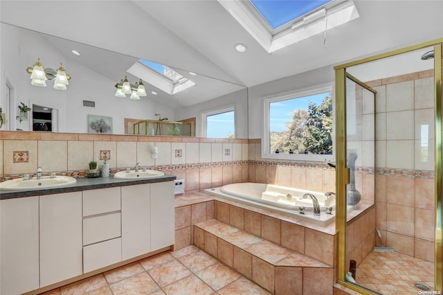 bathroom featuring vaulted ceiling with skylight, tile patterned flooring, shower with separate bathtub, and vanity