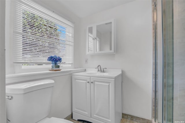 bathroom featuring vanity, toilet, and walk in shower