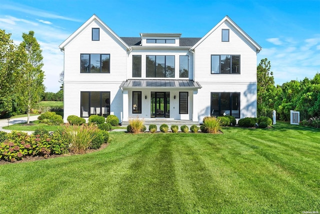 rear view of property featuring a lawn