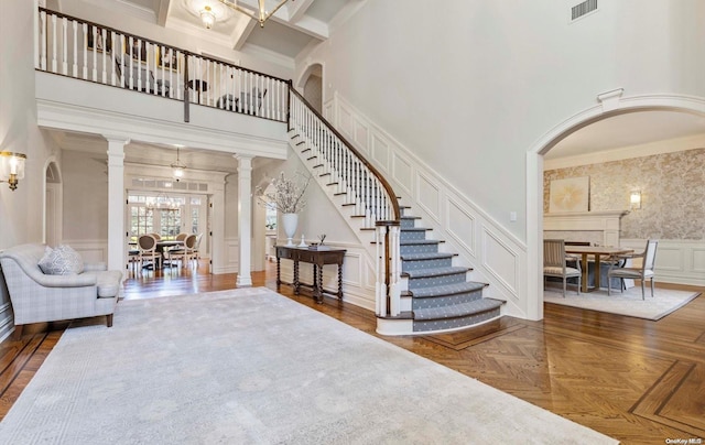 entryway with parquet flooring, a high ceiling, and ornamental molding