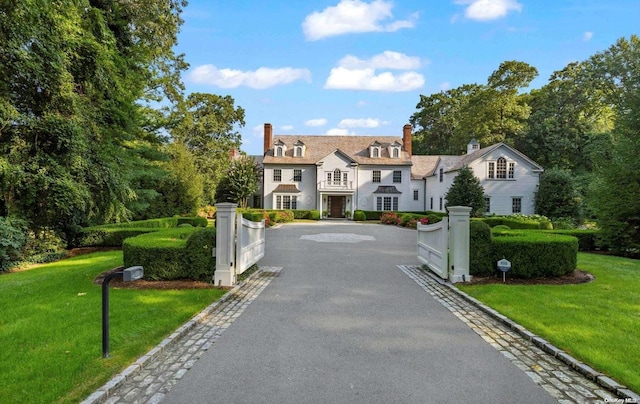 650 Chicken Valley Rd, Matinecock, NY 11560 - view of front facade with a chimney, a front yard, and a gate