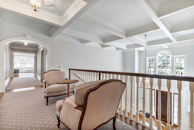 corridor with beamed ceiling, ornamental molding, a wealth of natural light, and coffered ceiling