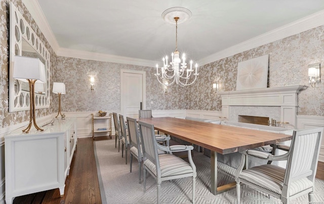 dining room featuring dark hardwood / wood-style floors, ornamental molding, and a notable chandelier