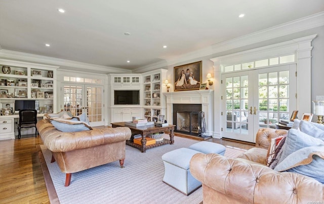 living room featuring crown molding, light hardwood / wood-style flooring, and french doors