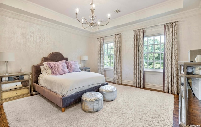 bedroom featuring a tray ceiling, a chandelier, crown molding, and dark wood-type flooring