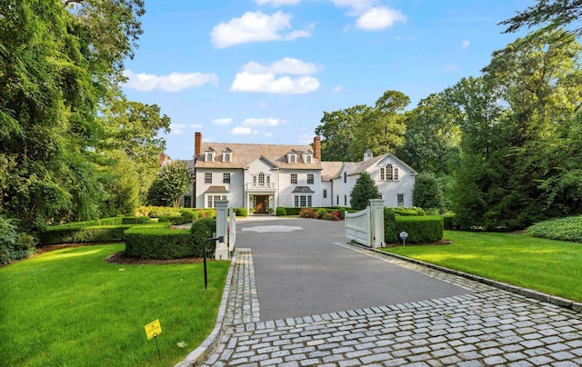 650 Chicken Valley Rd, Matinecock, NY 11560 - view of front facade with decorative driveway, a chimney, and a front yard