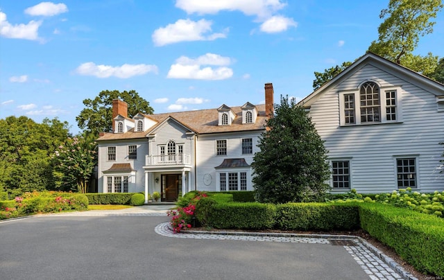 650 Chicken Valley Rd, Matinecock, NY 11560 - view of front facade with a chimney and a balcony