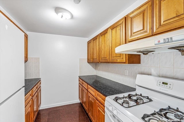 kitchen with white appliances, backsplash, dark stone counters, and range hood