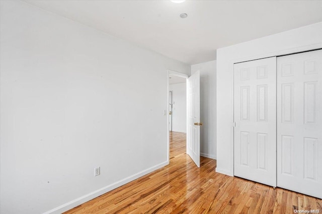 unfurnished bedroom featuring a closet and light hardwood / wood-style flooring