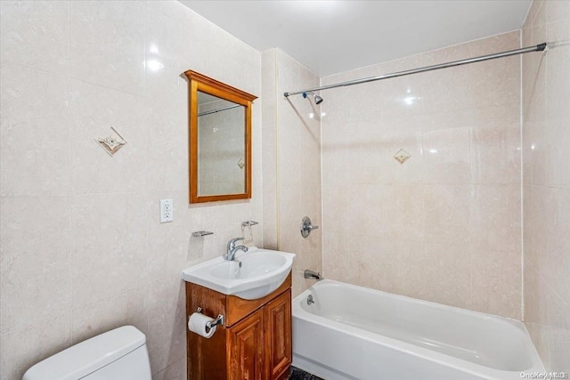 full bathroom with vanity, toilet, tile walls, and tiled shower / bath combo