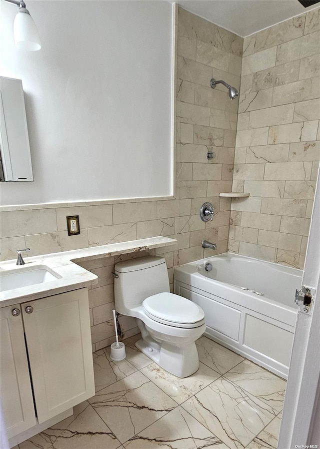 full bathroom with vanity, tiled shower / bath, tile walls, and toilet