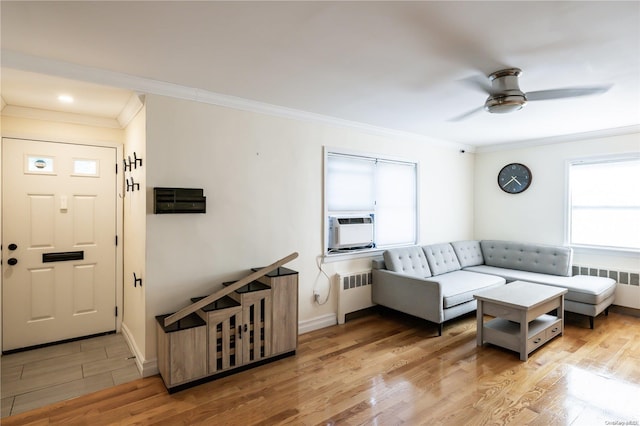 living room featuring radiator heating unit, light hardwood / wood-style flooring, ceiling fan, and ornamental molding