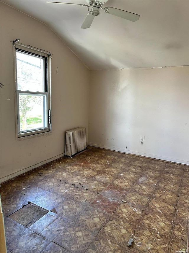 additional living space with radiator, lofted ceiling, and ceiling fan