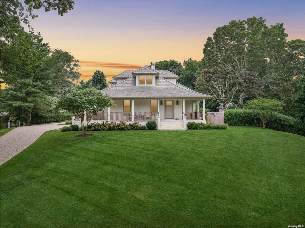 farmhouse-style home featuring a porch and a yard