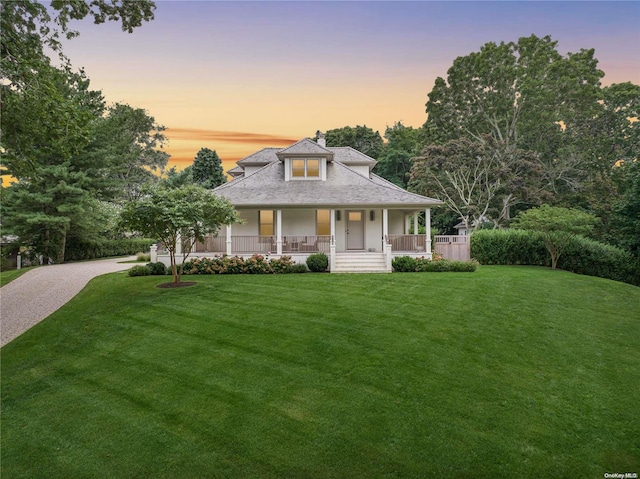 farmhouse-style home featuring a porch and a yard