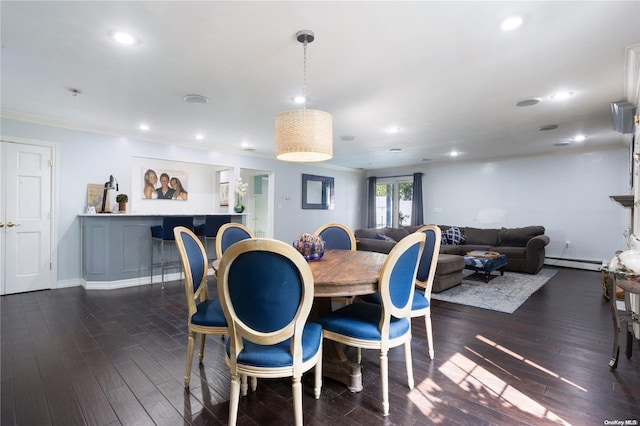 dining area featuring dark hardwood / wood-style flooring, baseboard heating, and crown molding