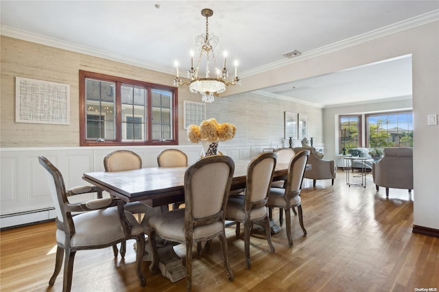 dining room featuring baseboard heating, crown molding, a chandelier, and hardwood / wood-style flooring