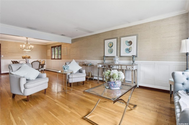 living room featuring ornamental molding, hardwood / wood-style flooring, baseboard heating, and a notable chandelier