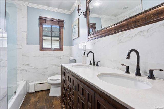 bathroom with ornamental molding, vanity, a baseboard radiator, hardwood / wood-style flooring, and tile walls