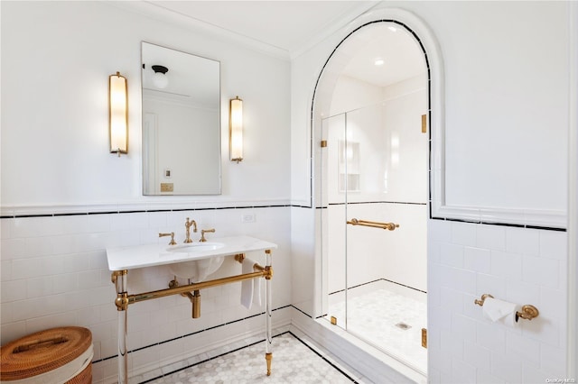 bathroom featuring crown molding, a shower with door, and tile walls