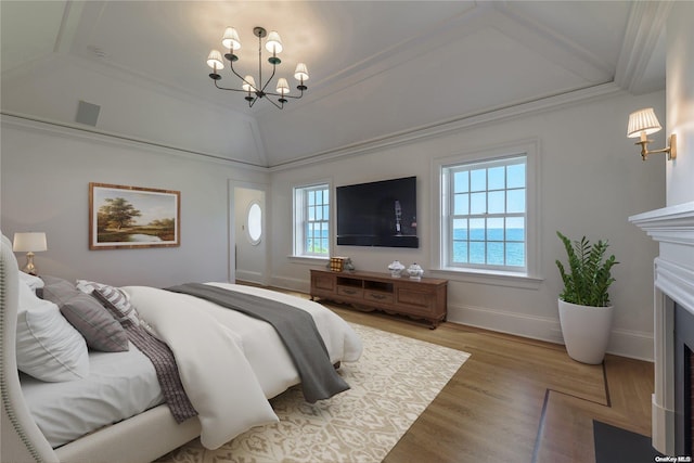 bedroom featuring hardwood / wood-style floors, ornamental molding, and a notable chandelier