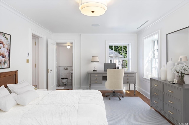 bedroom with dark hardwood / wood-style flooring, ornamental molding, and ensuite bath