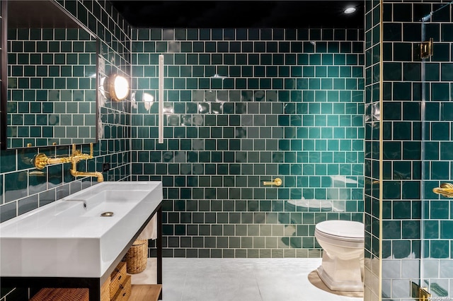 bathroom with tile patterned floors, vanity, toilet, and tile walls