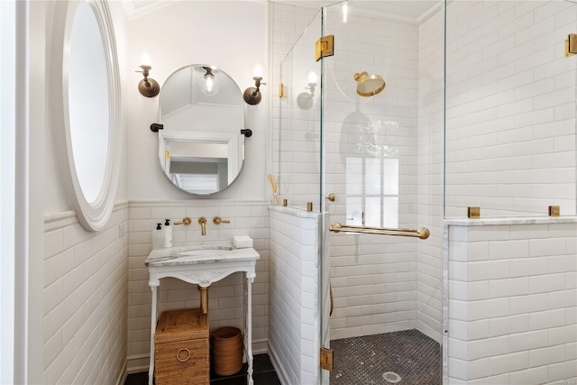 bathroom featuring an enclosed shower, ornamental molding, and tile walls