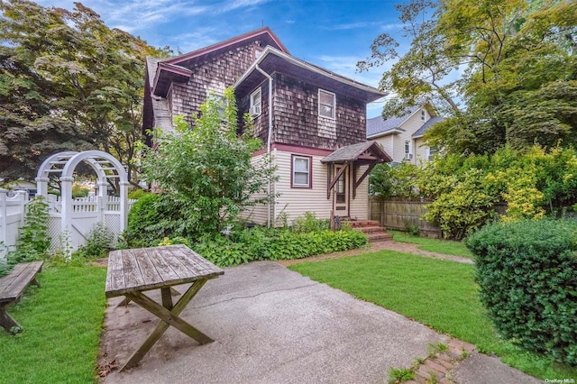 rear view of house featuring a patio area and a lawn