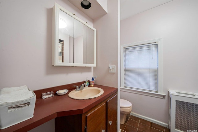 bathroom with tile patterned floors, radiator, vanity, and toilet