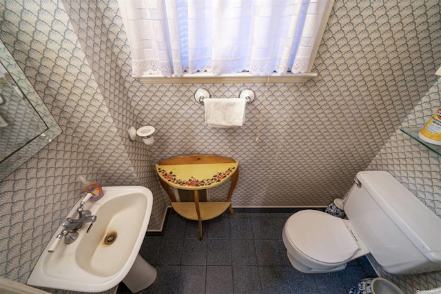 bathroom featuring toilet and tile walls