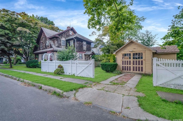 view of front of property featuring a front yard, an outdoor structure, and a garage