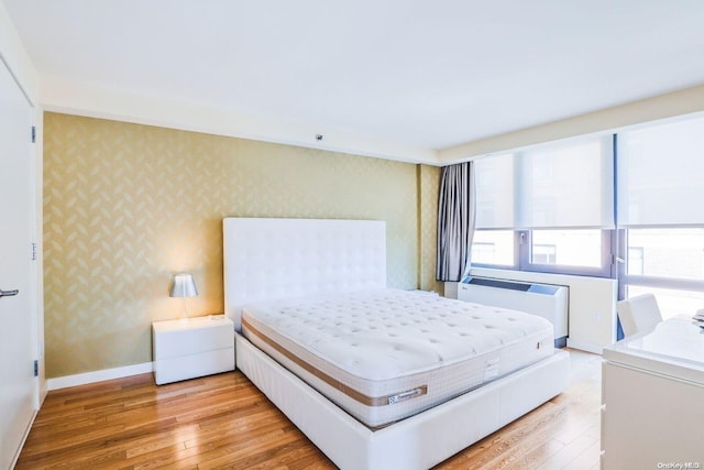 bedroom with radiator heating unit and light hardwood / wood-style flooring