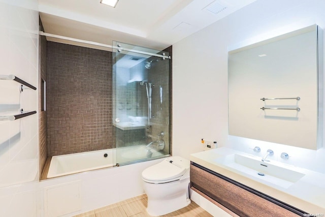 full bathroom featuring shower / bath combination with glass door, vanity, tile patterned flooring, and toilet