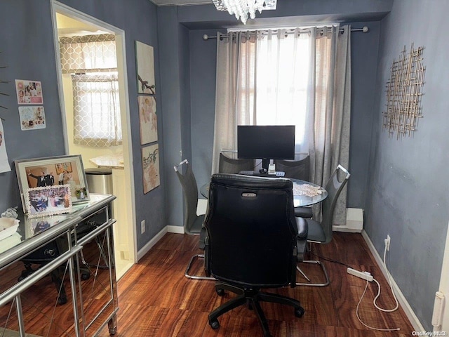 office space with an inviting chandelier, a wealth of natural light, and dark wood-type flooring